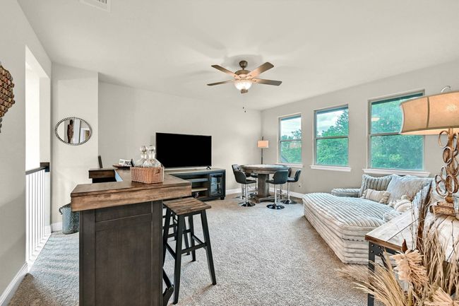 Living area with light carpet, baseboards, and ceiling fan | Image 26