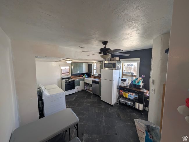 Kitchen with a sink, washer / clothes dryer, ceiling fan, and stainless steel appliances | Image 11