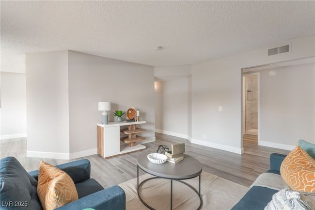 Living area with light wood-style flooring and a textured ceiling | Image 6