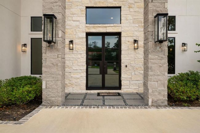 This impressive entrance showcases a striking blend of stone accents and soaring rooflines, designed to create a warm and inviting welcome. | Image 6
