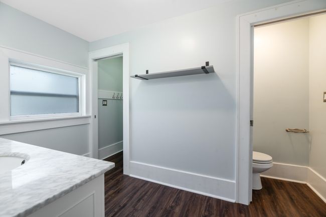 Bathroom featuring wood finished floors, toilet, baseboards, and vanity | Image 23