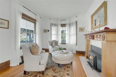 Living area with light hardwood / wood-style floors and a wood stove | Image 3