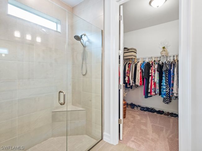 Revitalize in the generous shower that invites sunlight through a window above and features a built-in seat as well as a convenient niche for all your bathing essentials behind a frameless glass enclosure | Image 18