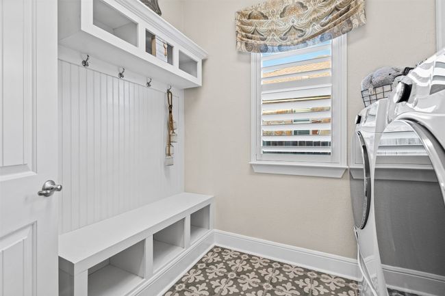 The fully renovated laundry room is as practical as it is stylish, featuring a built-in drop zone for coats and bags, ample cabinetry, and smart lighting for added functionality. | Image 29