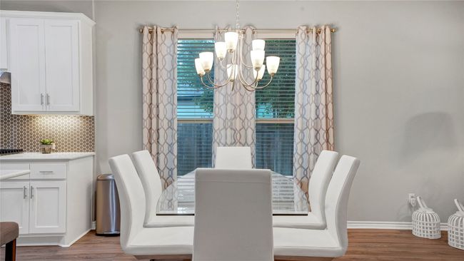 Dining area with baseboards, wood finished floors, and a chandelier | Image 13