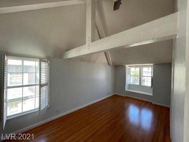 Unfurnished room featuring vaulted ceiling with beams, baseboards, and wood finished floors | Image 8