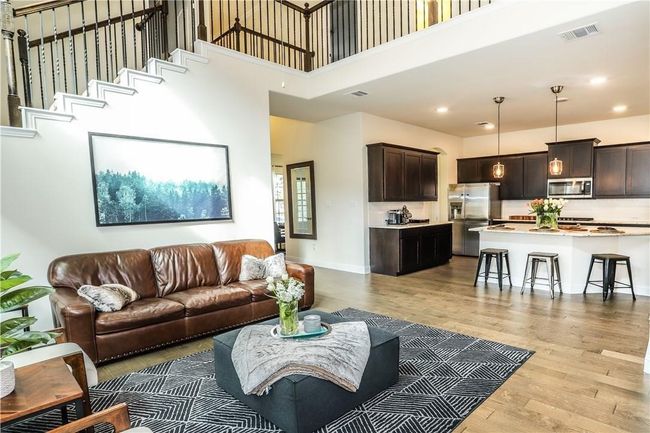 Living area with light wood-style flooring, a towering ceiling, and recessed lighting | Image 13