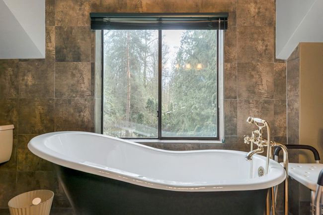Bathroom with tile walls, a healthy amount of sunlight, and a freestanding bath | Image 29