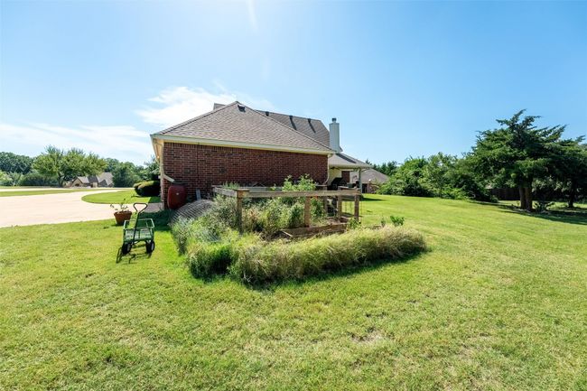 View of home's exterior with a chimney, a yard, and brick siding | Image 19