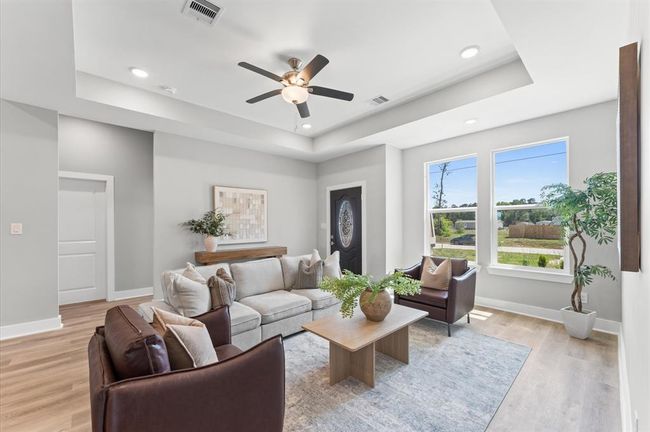 Open-concept living area featuring high ceilings, LED lighting, and plenty of natural light | Image 6
