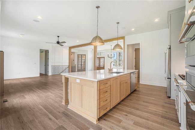 Kitchen with a sink, light brown cabinets, open floor plan, light wood finished floors, and recessed lighting | Image 28
