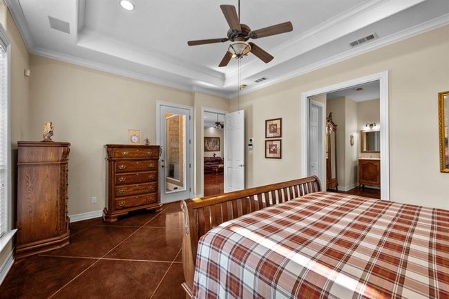 View toward the private patio door and dual bath entrances, showcasing easy access to outdoor relaxation and the spa-style primary bath beyond. | Image 25