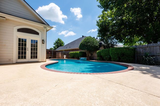 View of swimming pool with a patio, a fenced backyard, and french doors | Image 11