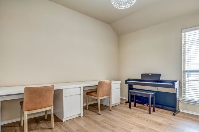 Office area with light wood-style floors, baseboards, vaulted ceiling, and plenty of natural light | Image 31