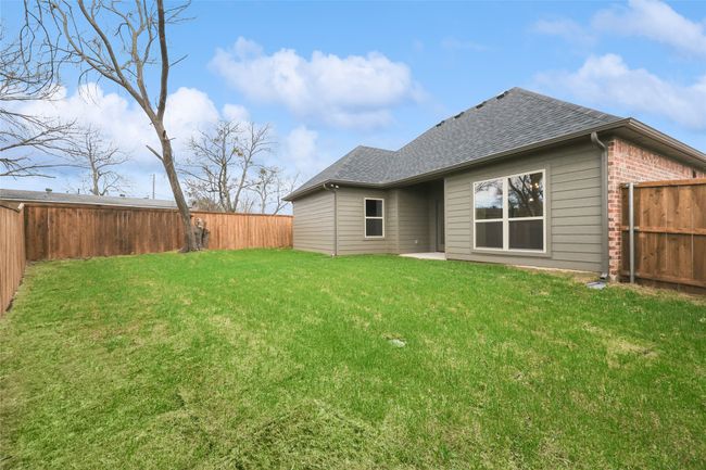 Large grassy yard featuring a shingled roof and brick siding | Image 16