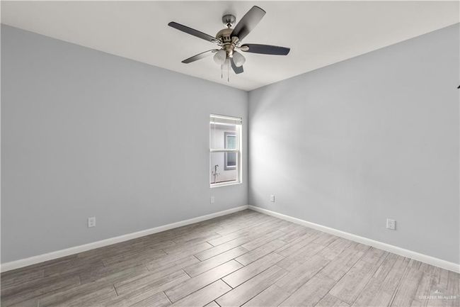 Spare room featuring a ceiling fan, wood finished floors, and baseboards | Image 6