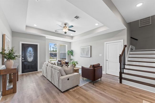 Open-concept living area featuring high ceilings, LED lighting, and plenty of natural light | Image 8