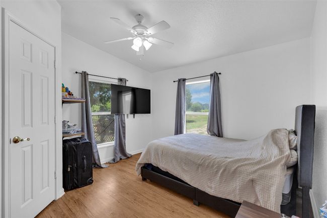 Bedroom with lofted ceiling, light wood-style flooring, multiple windows, and a ceiling fan | Image 22