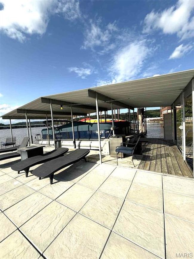 View of patio / terrace with a boat dock, boat lift, and a water view | Image 32