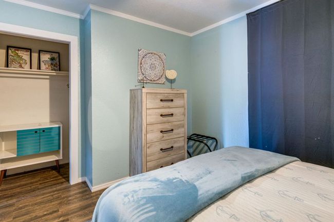 Bedroom with dark wood-style flooring, crown molding, and baseboards | Image 18