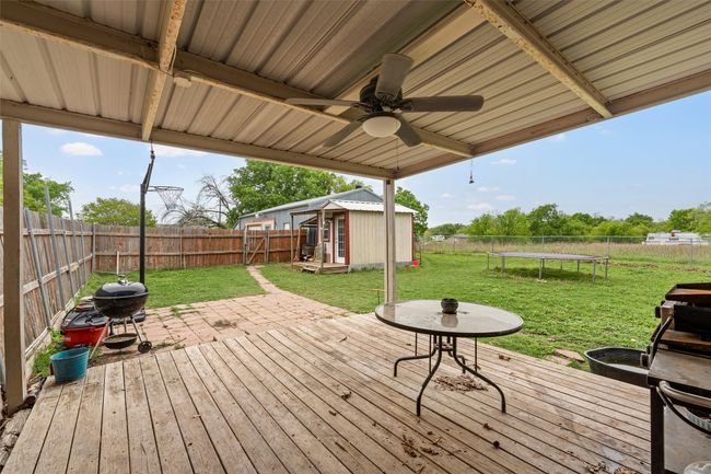 Wooden deck with a trampoline, a yard, and a fenced backyard | Image 18