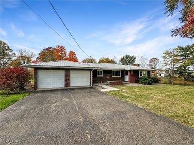 Single story home featuring a front yard and a garage | Image 1