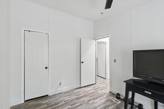 Office area with wood finished floors, visible vents, baseboards, and ceiling fan | Image 23