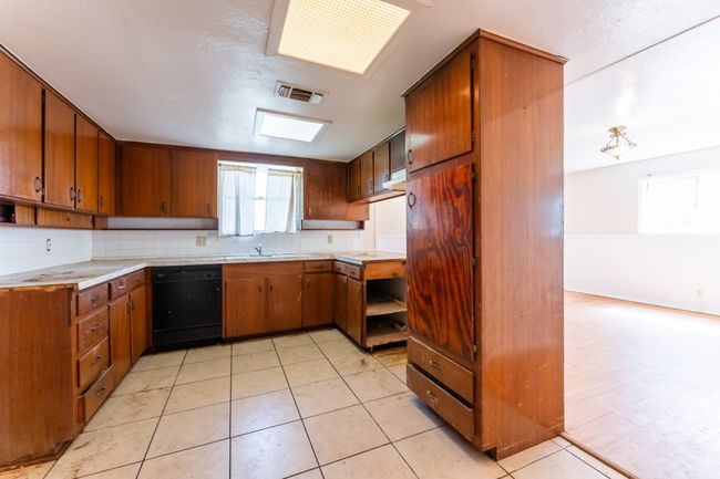 Kitchen with visible vents, brown cabinets, tasteful backsplash, and dishwasher | Image 12