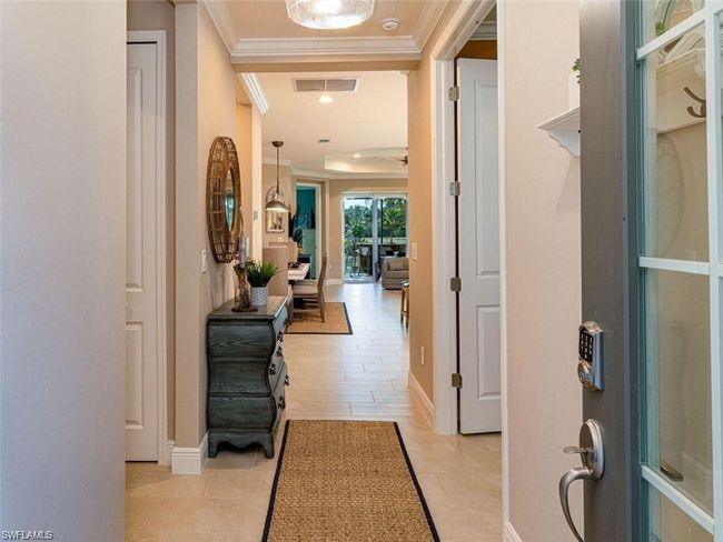 Hallway with crown molding and light tile patterned floors | Image 17