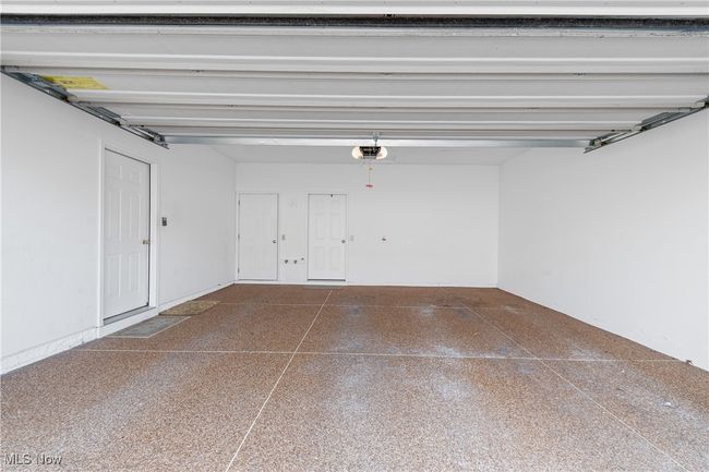 Two-car garage has Naturestone floor, utility closet, and large storage closet at the back. | Image 24