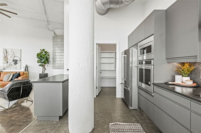 Kitchen featuring appliances with stainless steel finishes, dark countertops, gray cabinetry, ceiling fan, and open floor plan | Image 20