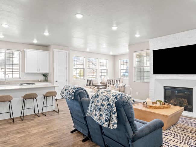 Living area with light wood-style floors, recessed lighting, a fireplace, and a textured ceiling | Image 8