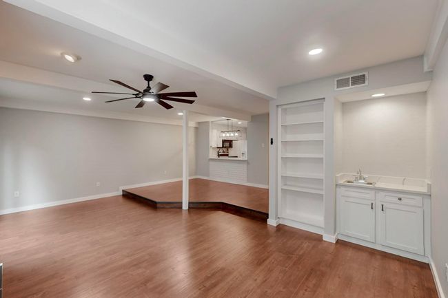 Unfurnished living room featuring a sink, visible vents, ceiling fan, and baseboards | Image 12