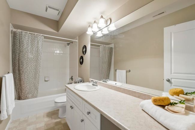 Bathroom featuring shower / tub combo, visible vents, vanity, and toilet | Image 28