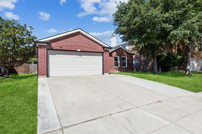 View of front of property with a garage and a front yard. Grass has been digitally enhanced | Image 2