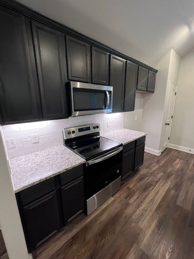Kitchen with appliances with stainless steel finishes, tasteful backsplash, dark cabinets, and vaulted ceiling | Image 28