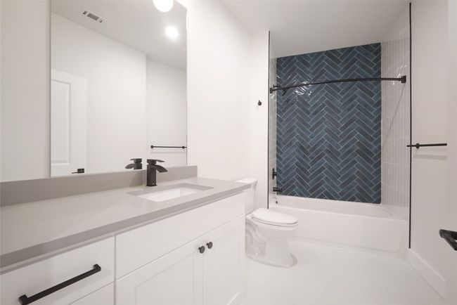 Bathroom featuring vanity, toilet, and bathing tub / shower combination | Image 12