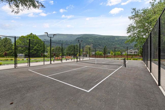 View of tennis court with a mountain view and fence | Image 36