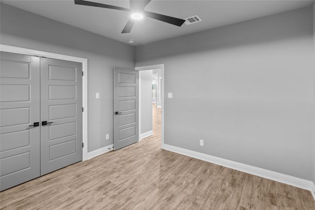 Unfurnished bedroom with wood finished floors, a closet, and a ceiling fan | Image 23
