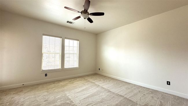 Unfurnished room with light colored carpet and a ceiling fan | Image 9
