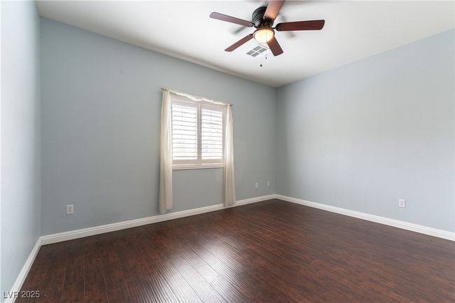 Bedroom featuring baseboards, visible vents, dark wood-style flooring, and a ceiling fan | Image 17