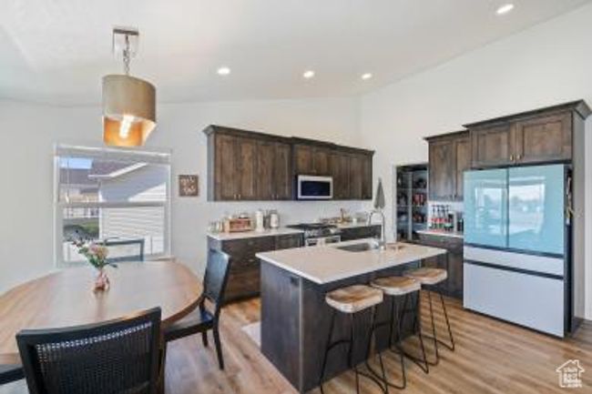 Kitchen featuring freestanding refrigerator, dark brown cabinetry, stainless steel microwave, and stove | Image 10