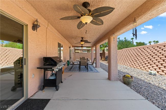 Fenced backyard with a grill, a patio area, a ceiling fan, and outdoor lounge area | Image 38