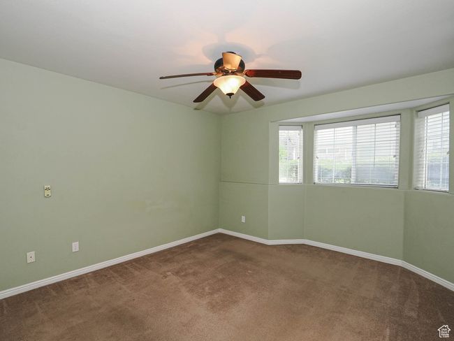 Carpeted spare room featuring ceiling fan, baseboards, and a healthy amount of sunlight | Image 13