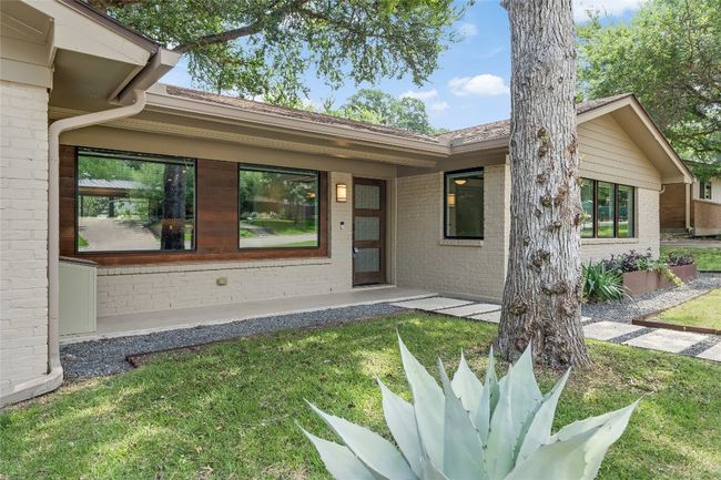 Gorgeous curb appeal with updated landscaping including welded steel mailbox, borders, and garden box, along with a xeriscape Leuder stone walkway leading to the chic front door. | Image 11