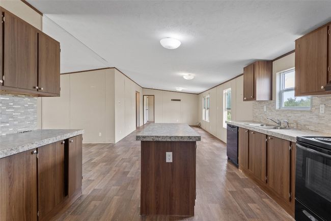 Kitchen featuring black appliances, backsplash, a center island | Image 17