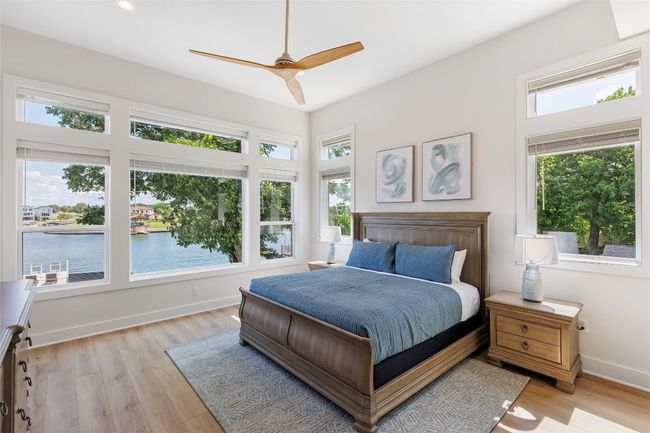 Primary Bedroom featuring light wood finished floors, a ceiling fan, a water view, and recessed lighting. | Image 22