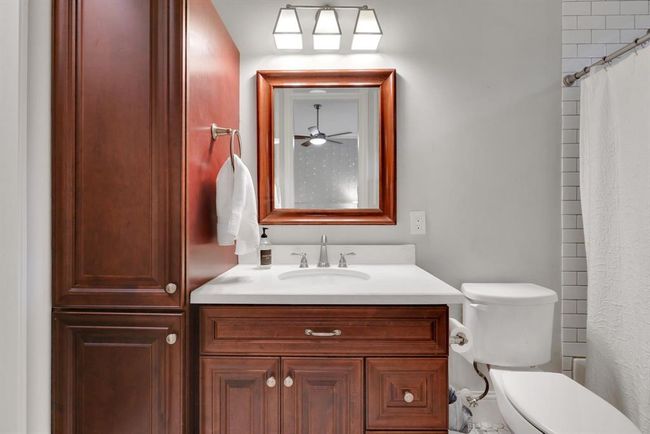 The ensuite bath connected to the secondary bedroom #3 has a single vanity topped in quartz and accented by brushed chrome fixtures. The tub/shower combination features a classic white subway tile surround, paired with stylish octagonal tile flooring. A nicely sized walk-in closet completes the suite, offering comfort and convenience. | Image 32