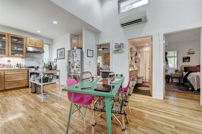 Dining room featuring light wood-style flooring, a towering ceiling, recessed lighting, and a wall unit AC | Image 36