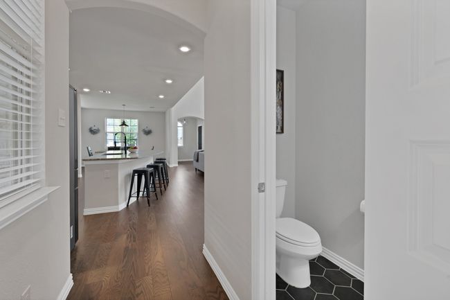 Hallway with powder bath featuring baseboards, recessed lighting, dark wood finished floors, arched walkways | Image 24